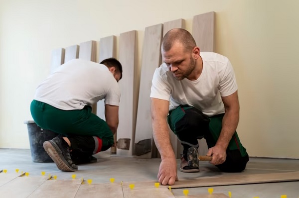 worker tiling floor in office