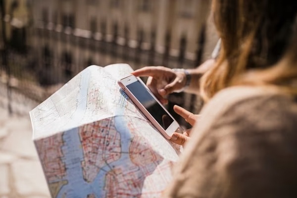 person hand holding paper map and smartphone
