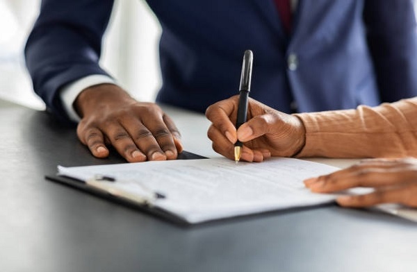 person doing a loan approval signature on paper