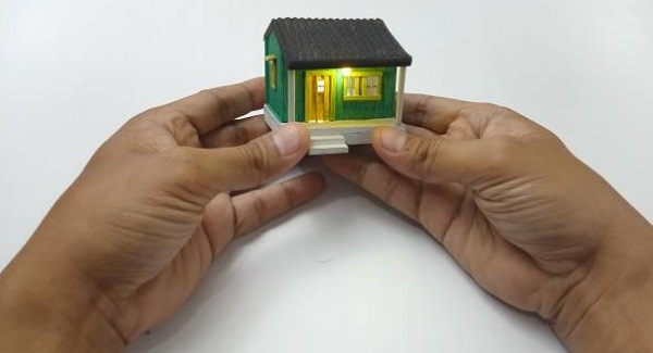 man hand holding tiny house