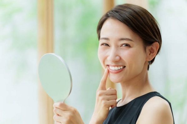 girl hand holding mirror and check your teeth