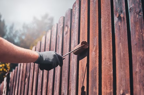 Worker color the wood fence