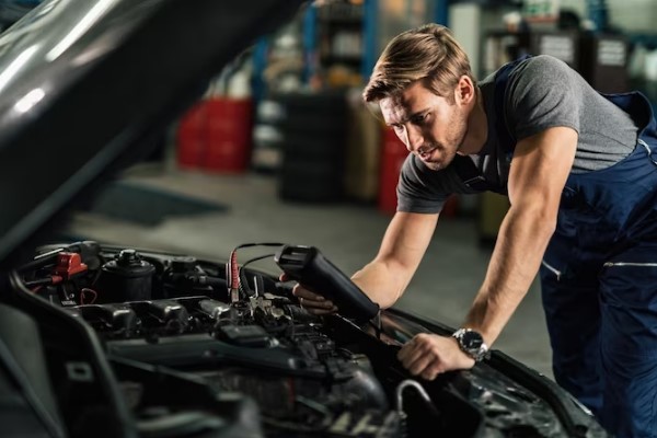 worker checking car engine