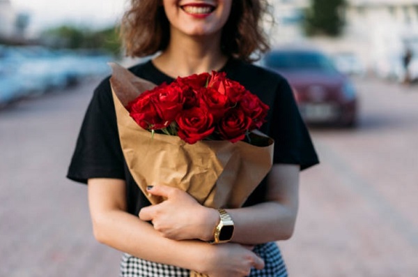 girl hand holding Red Rose Bouquet