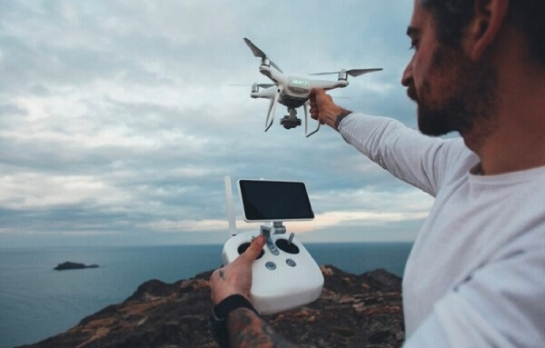 man holding drone and its controller