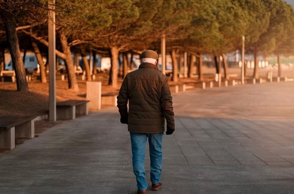 old man walking backward in the park