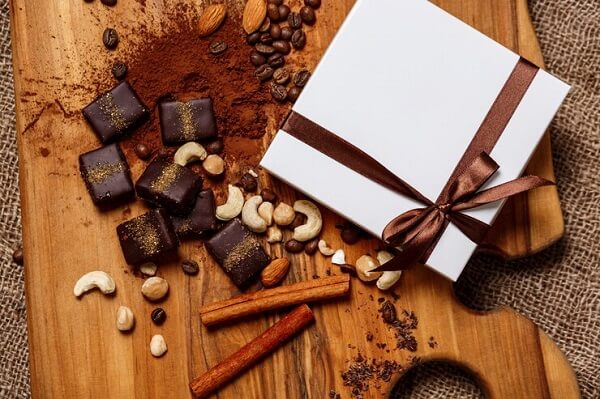 chocolate-candies-cinnamon-nuts-wood-desk