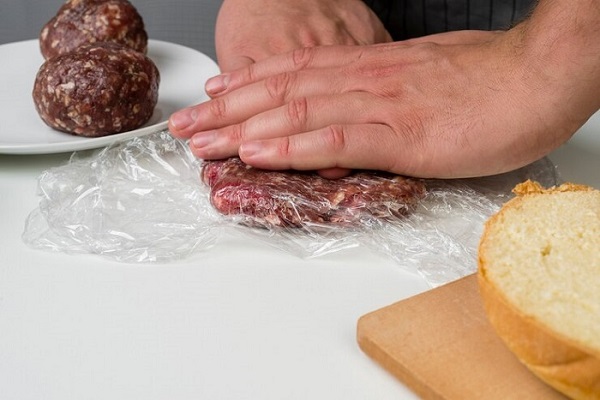 hands-press-meat-on-table
