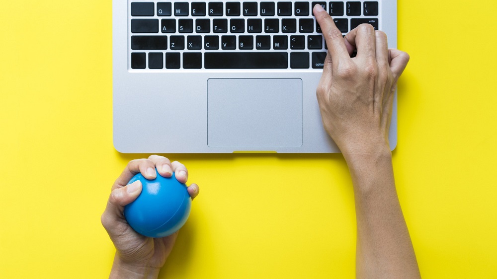 Person Use Laptop and Stress Ball