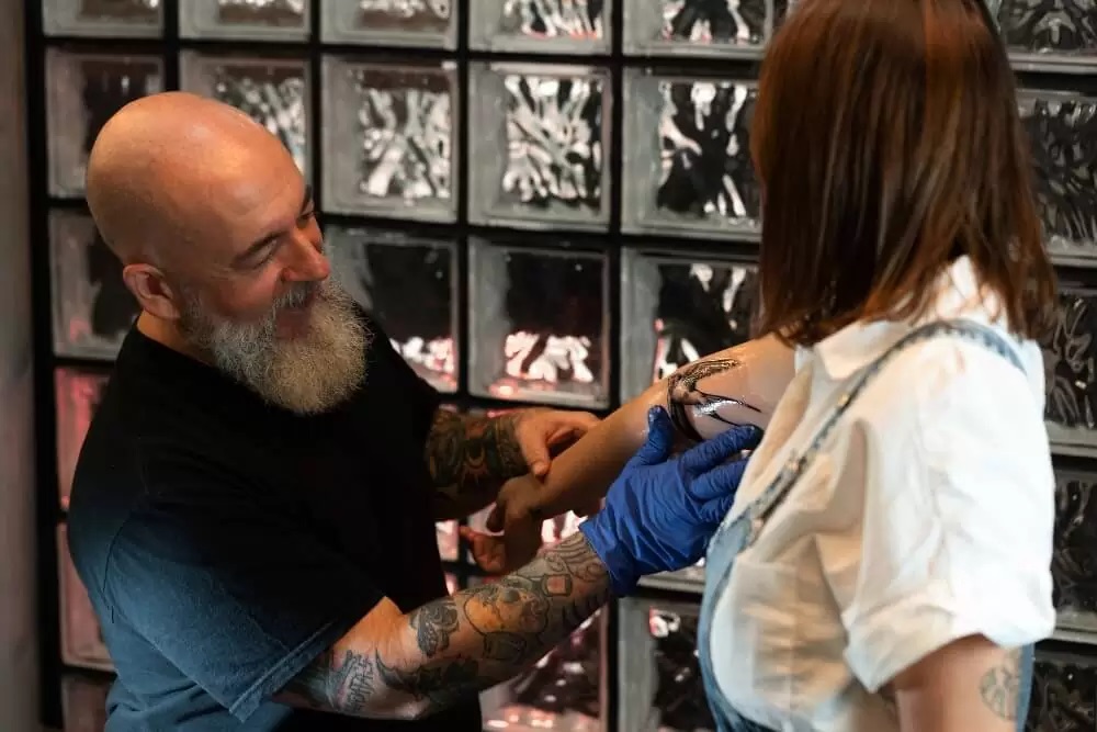 Old-Man-Create-a-Tattoo-in-Young-Girl-Arm