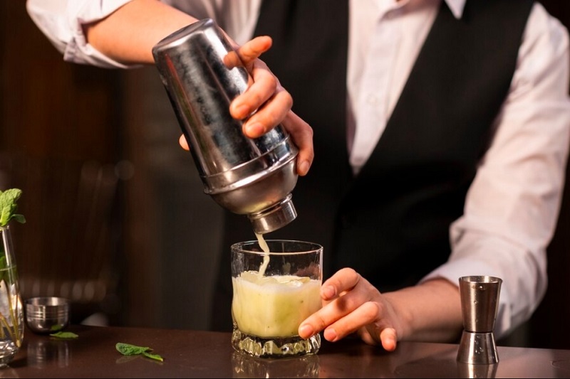 person making cocktail