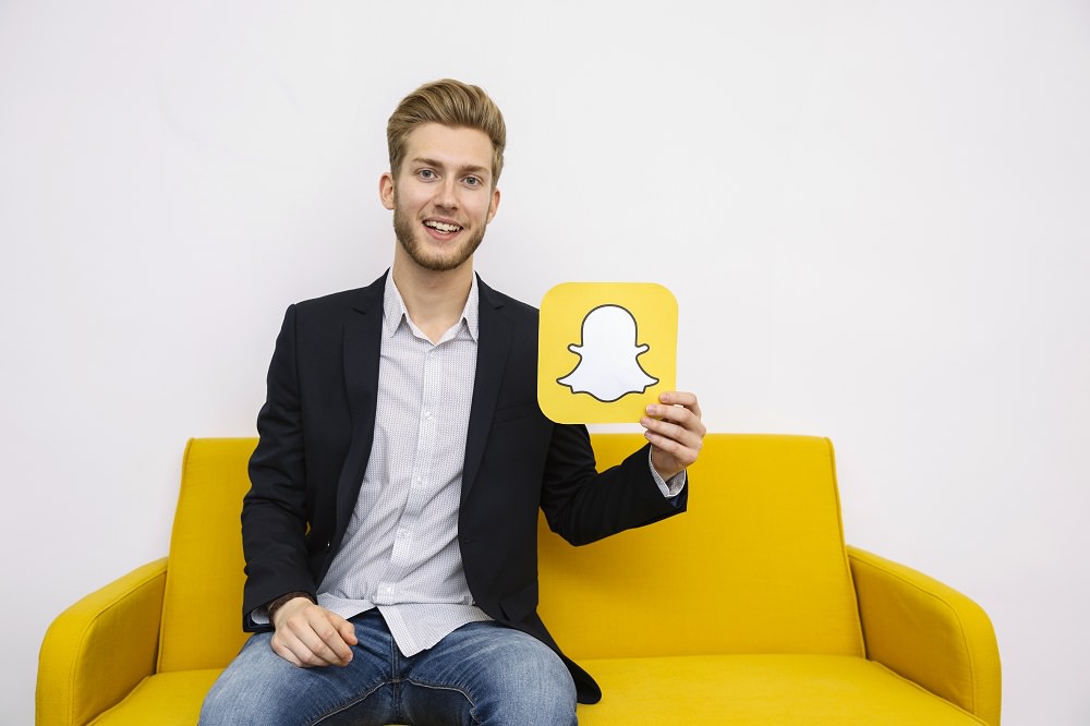 Young man hold a Snapchat Icon